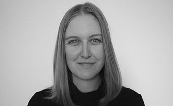 Head and shoulders black and white image of smiling your woman with fair hair