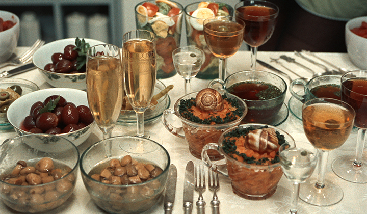 a table laid out with food and glasses of wine