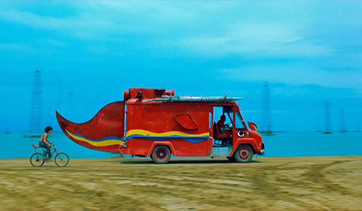 Red van shaped like a whale against a bright blue skyd 