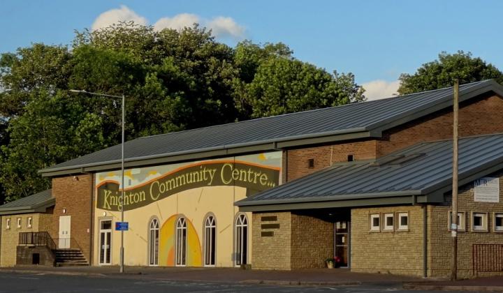 large community centre made of brick of different colours, wavy banner over the windows