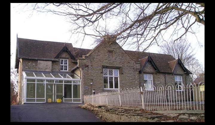 Old stone school house converted into community centre with glass foyer