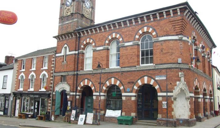 Tall red brick building with white facing on a street corner
