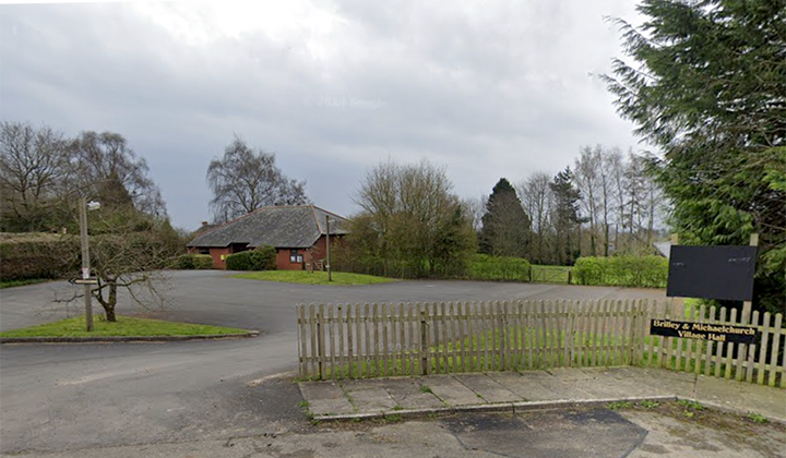 Driveway with modern brick village Hal visible in the distance