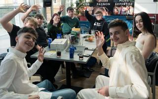 found men and women at table waving at camera