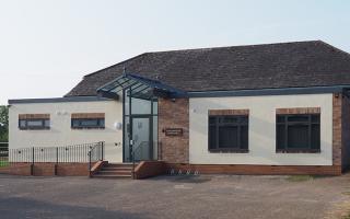 Low single storey village hall with cream-coloured rendering 