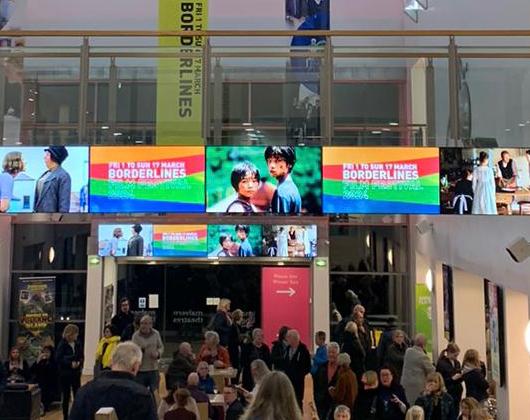 Digital multicoloured Borderlines banner in large theatre foyer